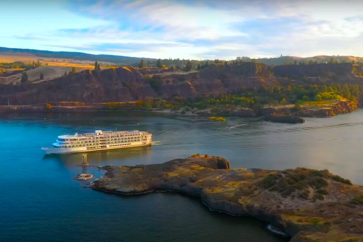 American Cruise Lines ship sailing the Columbia River Gorge at sunset