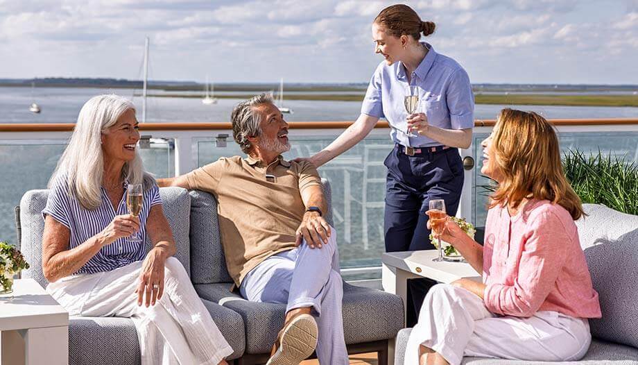 An American Cruise Lines staff member attending to guests on the deck.