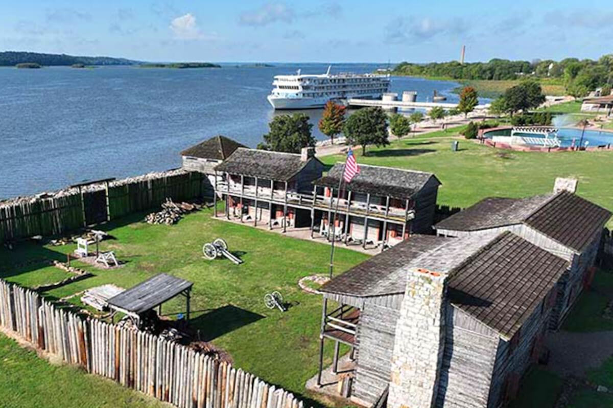 American Cruise Lines ship docked along the Mississippi River, with a historic fort in the foreground