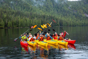 A group of kayakers cheering to the camera