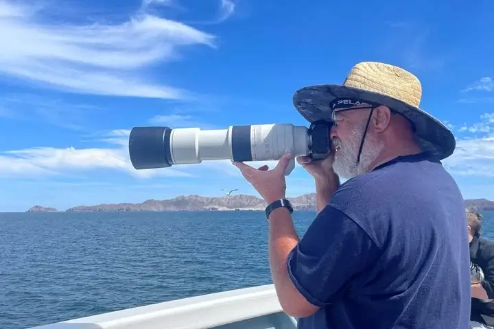 Photographer onboard ship taking photographs of subjects in the water