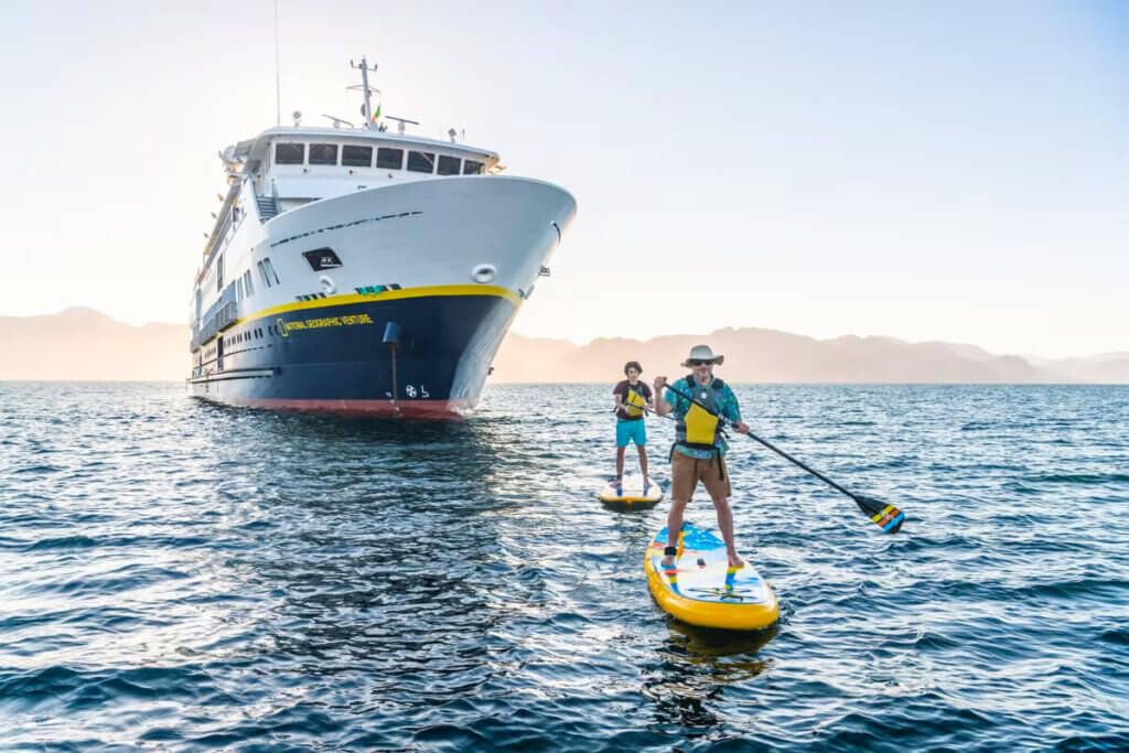 Two guests paddleboarding from the National Geographic Venture in the waters of the Sea of Cortez