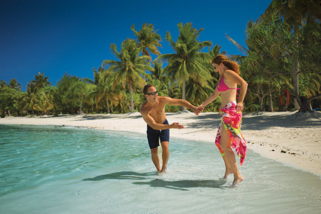 A couple playing on the beach in Bora Bora