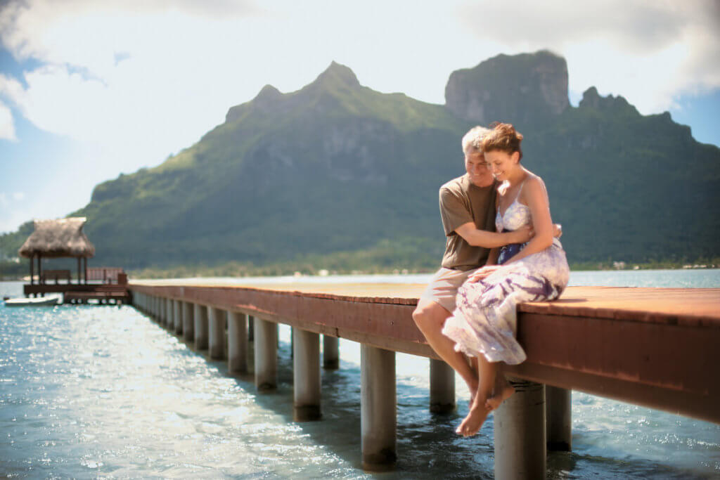 A couple sitting on the pier in Bora Bora