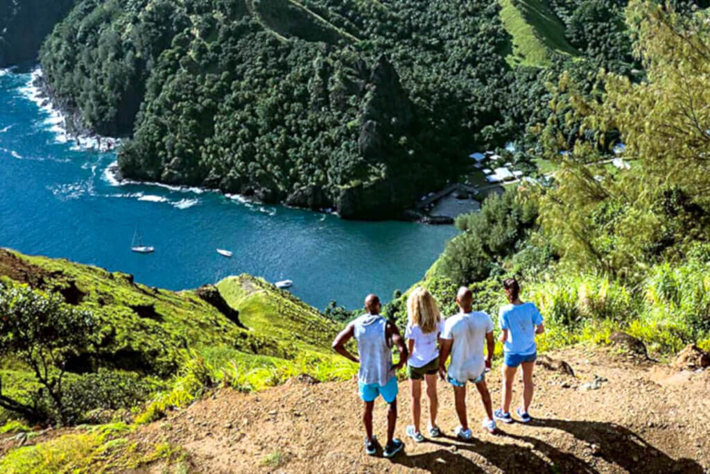 Two couples standing on a bluff overlooking the coast on Hapatoni, Tahuata, the Marquesas Islands