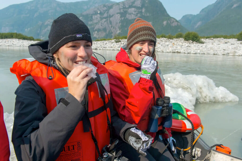 Skiff passengers tasting bergies in Thomas Bay near Baird Glacier