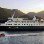 A skiff with cruise guests sails along side the Safari Endeavour