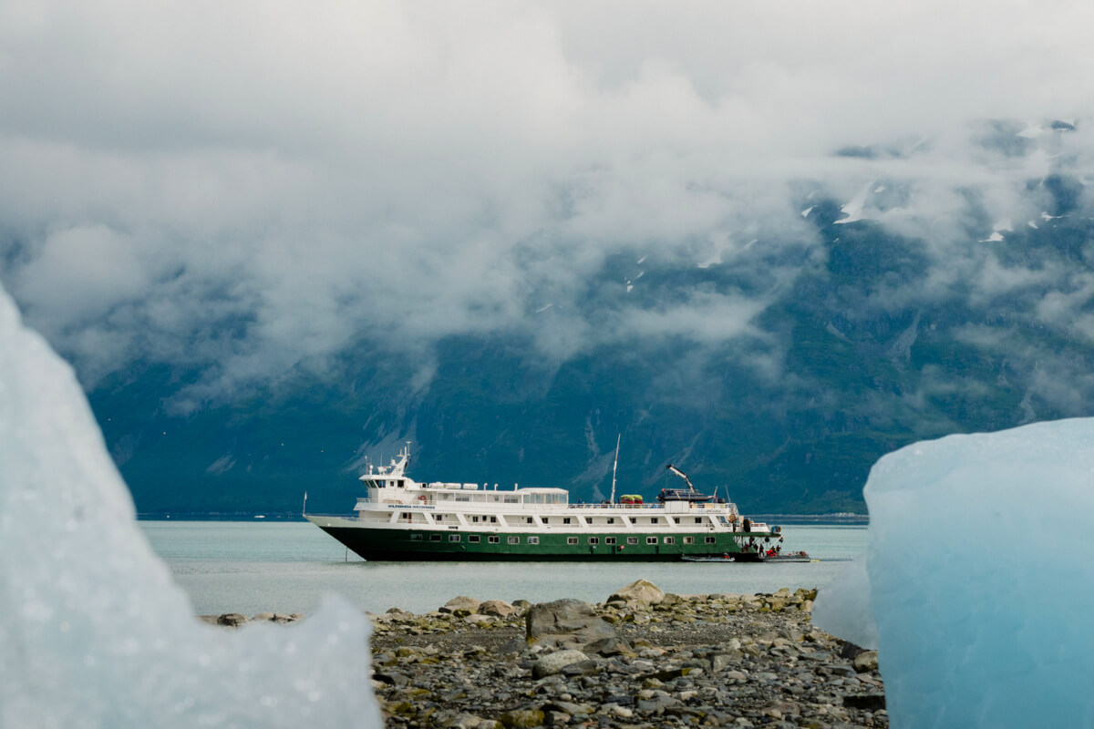 An Uncruise ship framed by icebergs
