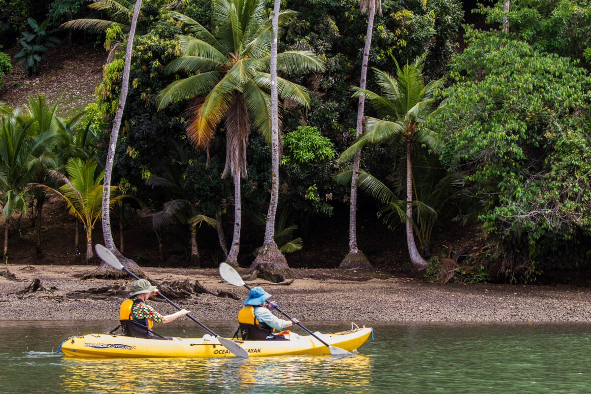 Two kayakers exploring a sandy beach of Costa Rica