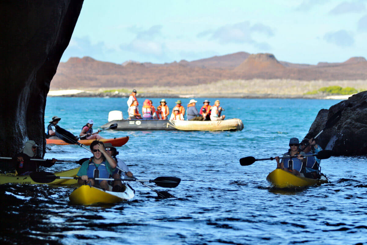 Guests kayaking though sea arch in the Galapagos Islands
