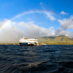 Safari Explorer off the coast of Hawaii with a rainbow