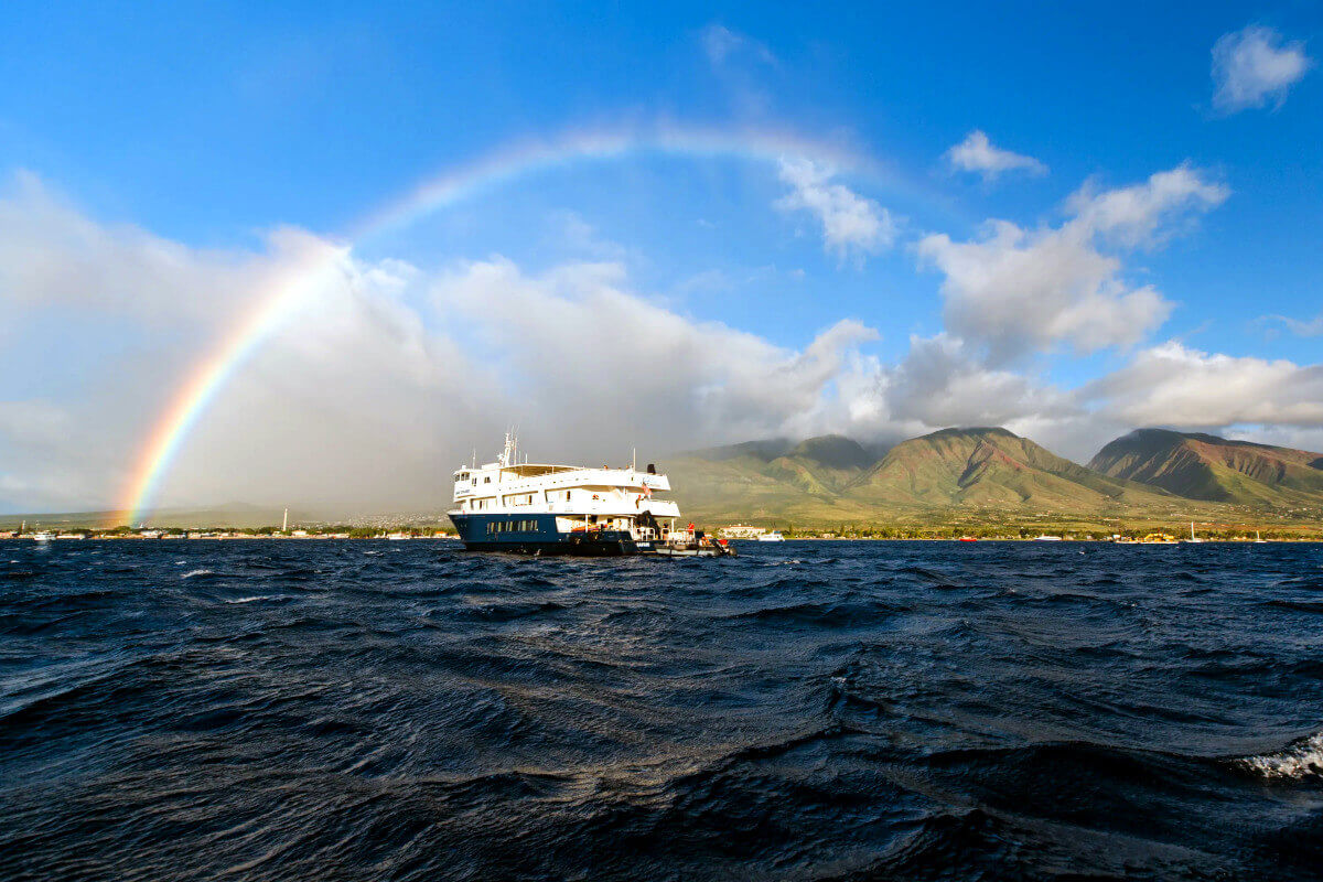 Safari Explorer off the coast of Hawaii with a rainbow