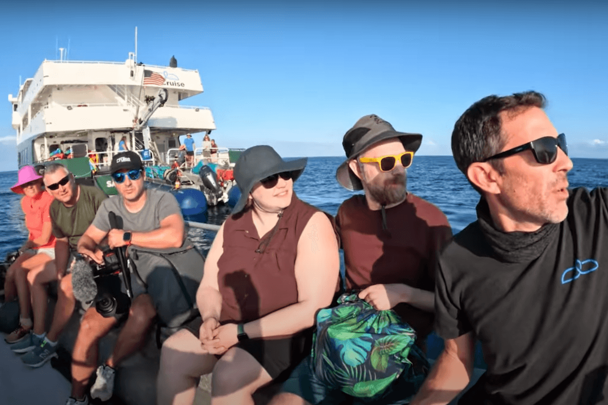 A skiff full of UnCruise guests as a guide describes the scenery of the coastline of Hawaii