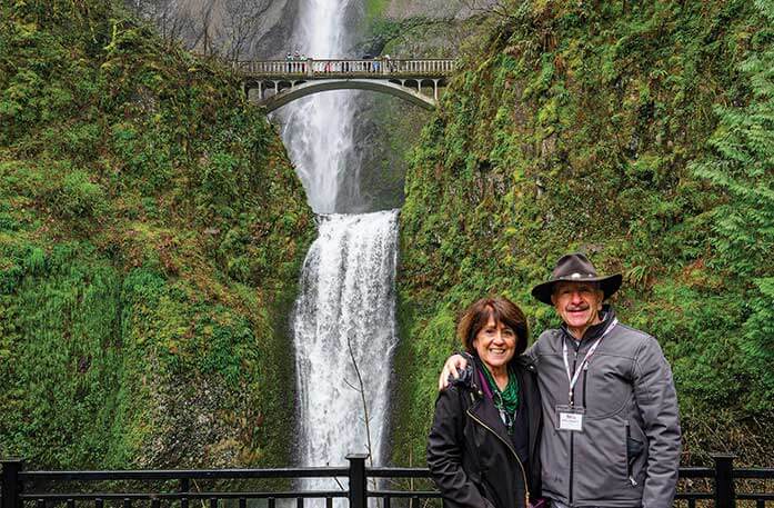 A couple posing in front of Multnomah Falls