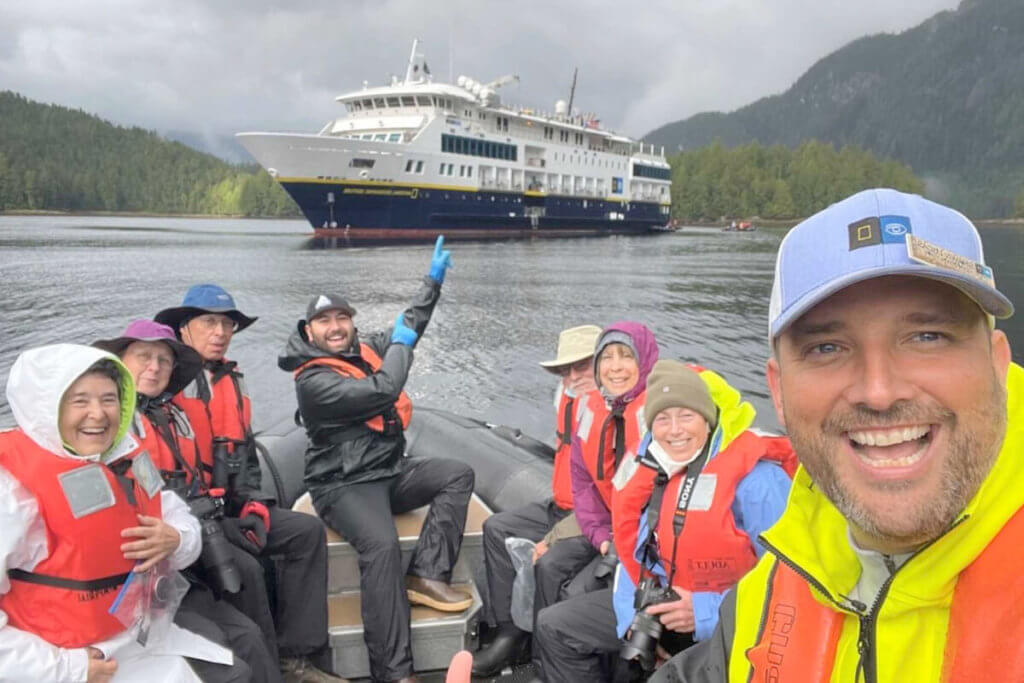 A zodiac filled with happy cruise guests in Lowe Inlet
