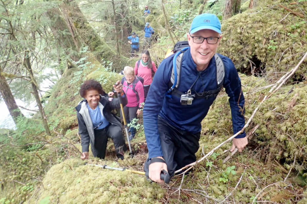 Guests hiking in an Alaskan rainforest