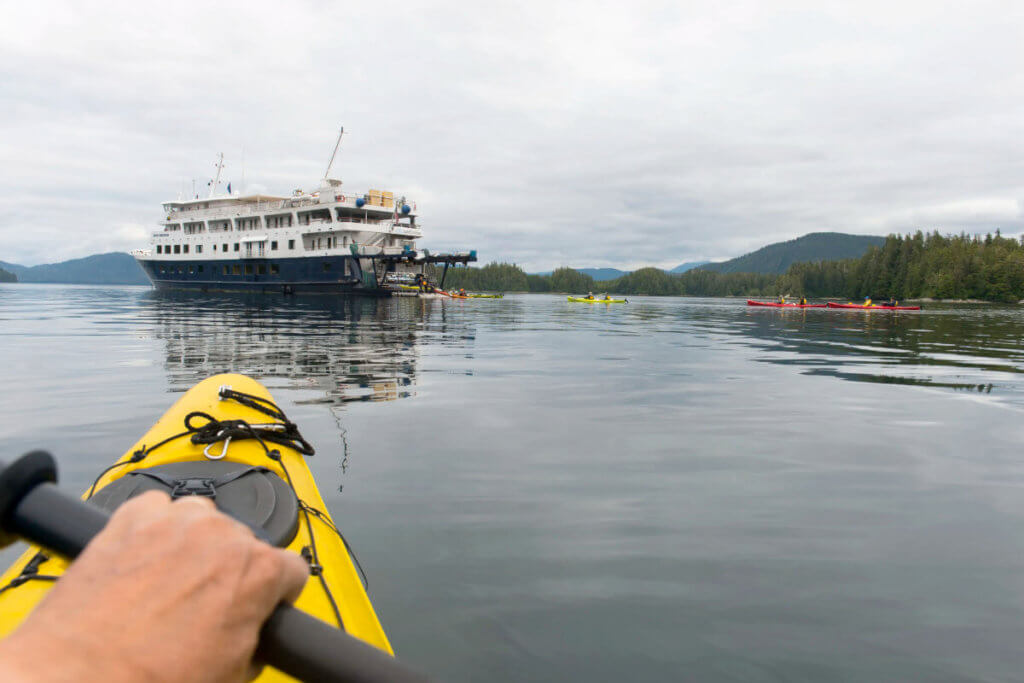 Guests kayaking near ship in Thomas Bay.