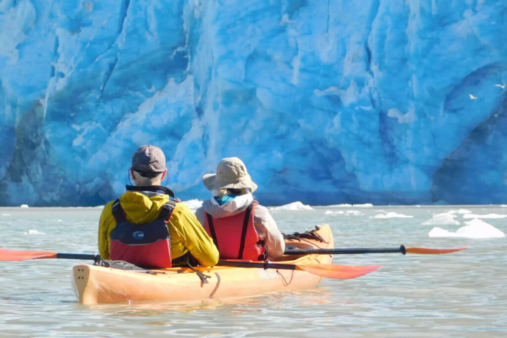 A couple kayaking near a glacier