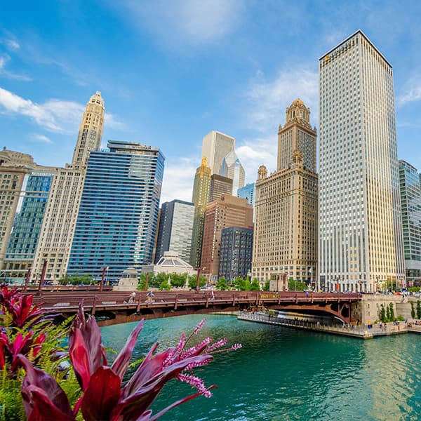 The Chicago River with the city's skyscrapers in the background, and a red bridge in the foreground